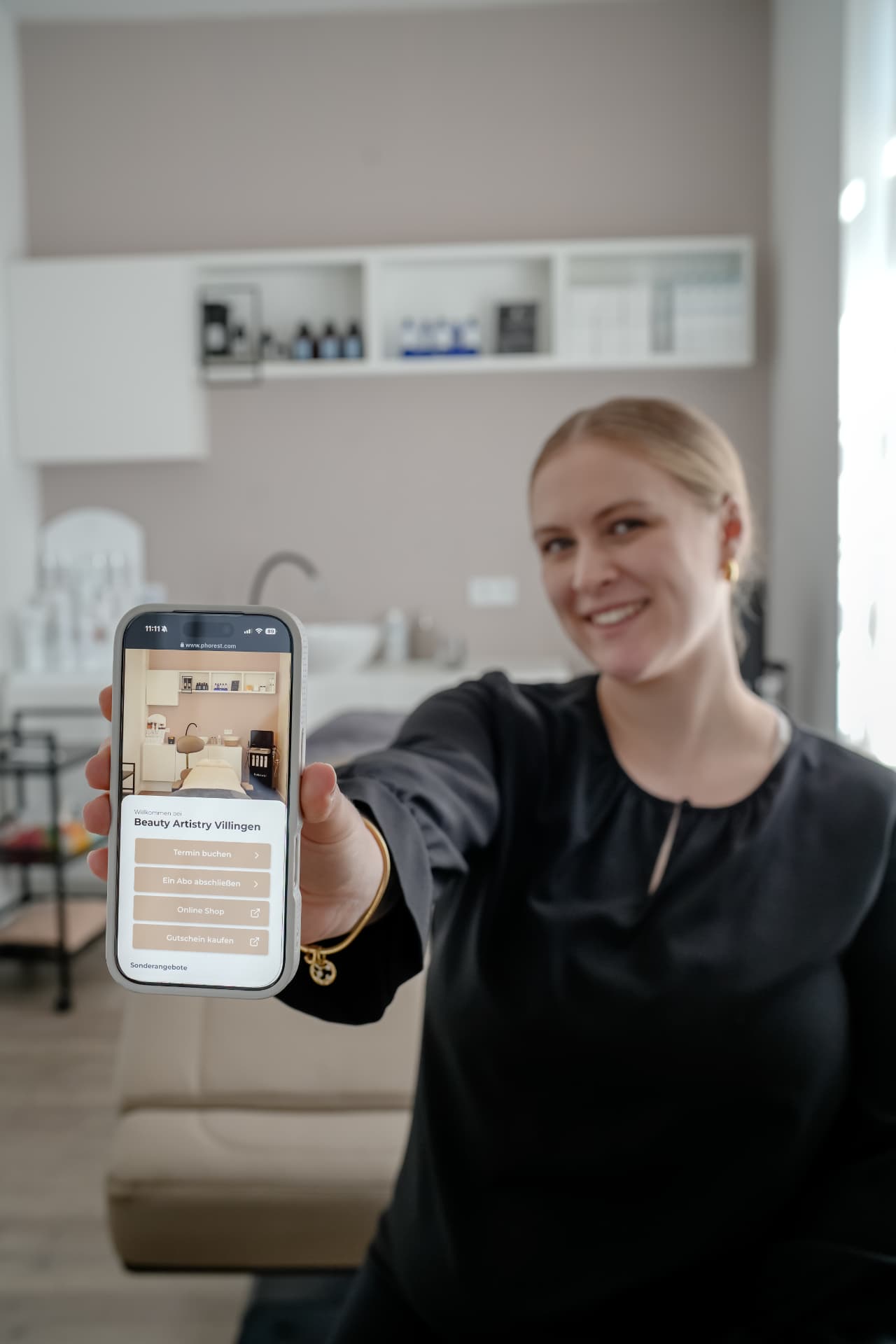 Jule Albertsen zeigt die Online-Terminbuchung von Beauty Artistry Villingen auf dem Handy